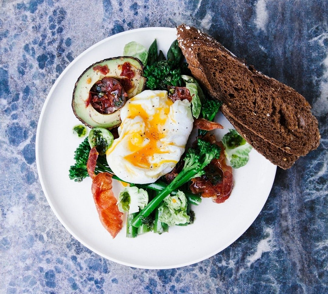 Näringsrik tallrik med pocherat ägg, avokado, grönsaker och rågbröd